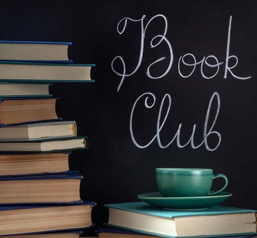 Stack of books beside a chalkboard reading Book Club