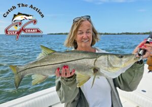Angler holding a large snook aboard a Gulf Coast Guide Service charter boat
