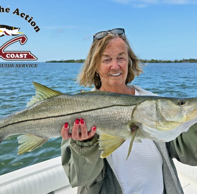 Angler holding a large snook aboard a Gulf Coast Guide Service charter boat