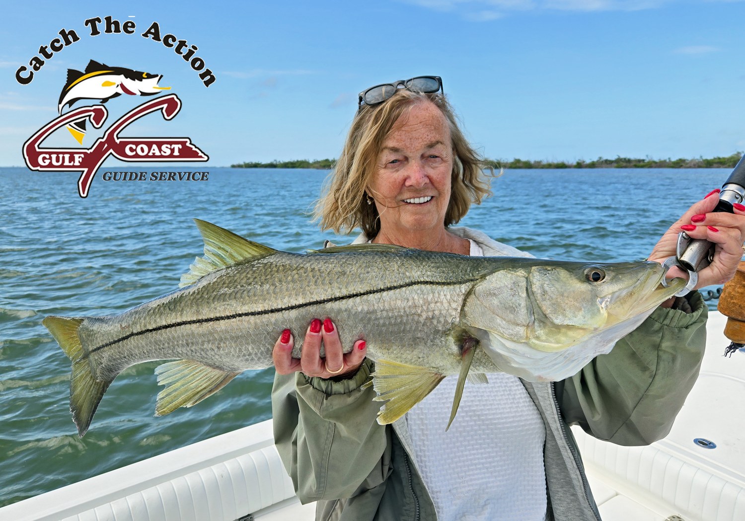 Angler holding a large snook aboard a Gulf Coast Guide Service charter boat