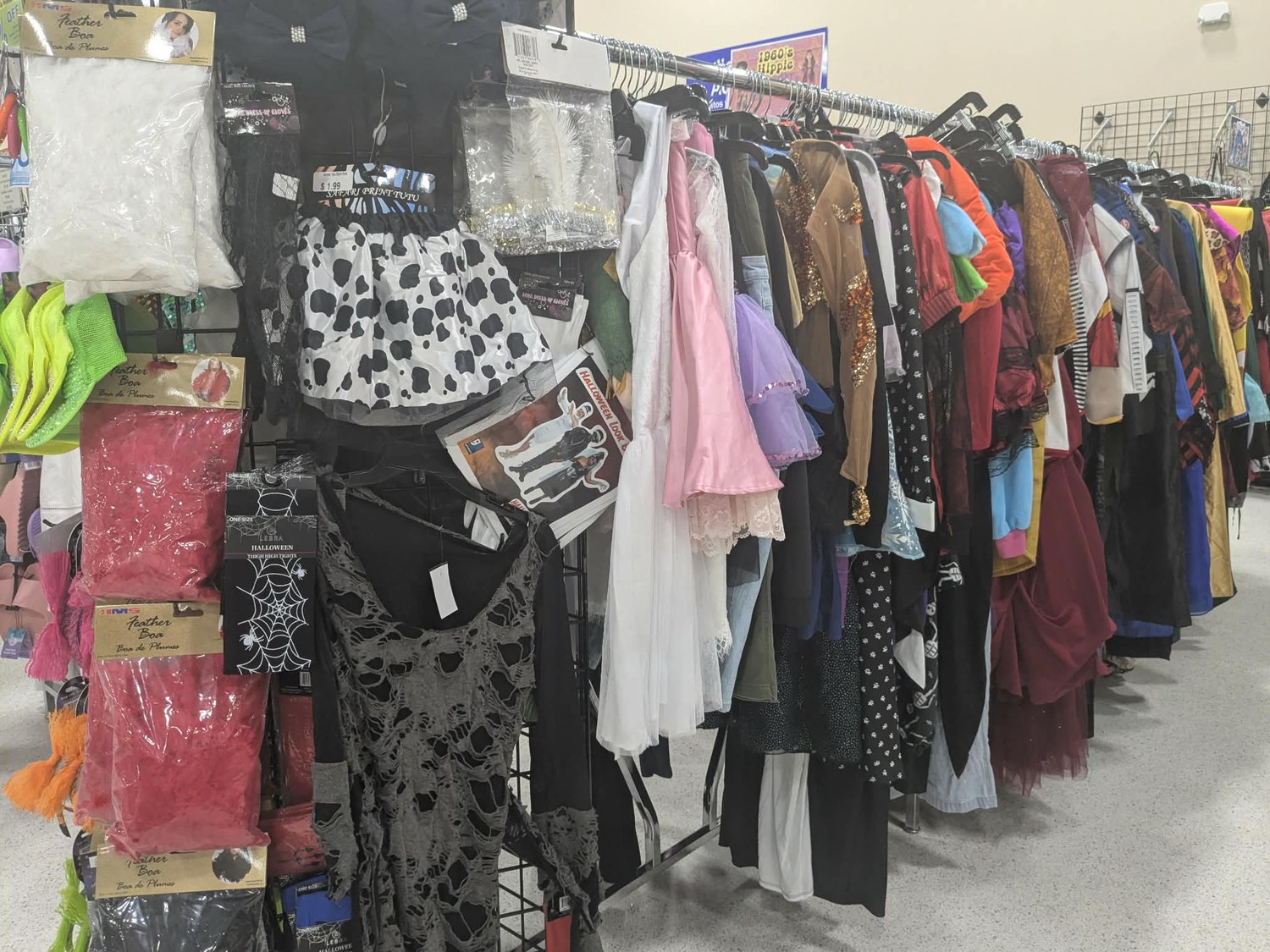 Rack of secondhand Halloween costumes, boas and accessories at Goodwill